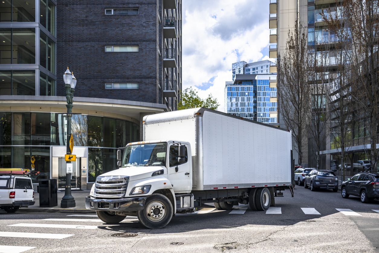White box truck making deliveries in city
